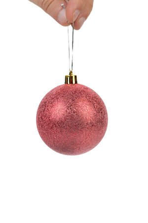 Red Christmas ball on a silver ribbon. Isolated over white background. Close-up.の写真素材