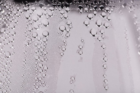 Drops and trickles of water on the glass. It occupies the entire surface of the image. Close-up.の写真素材