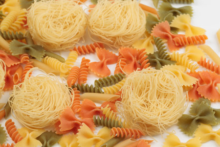 Tricolor macaroni of different types. It is located on a white surface. Close-up.の写真素材