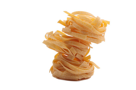 Italian fettuccine pasta in the form of a nest. Isolated over white background. Close-up.の写真素材