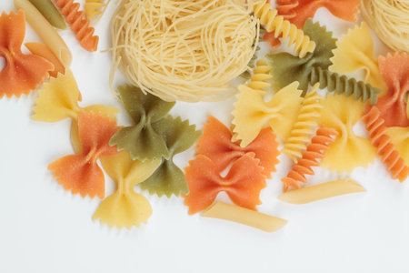 Tricolor macaroni of different types. It is located on a white surface. Close-up.の写真素材