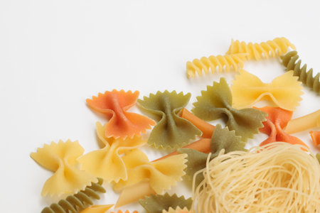 Tricolor macaroni of different types. It is located on a white surface. Close-up.の写真素材