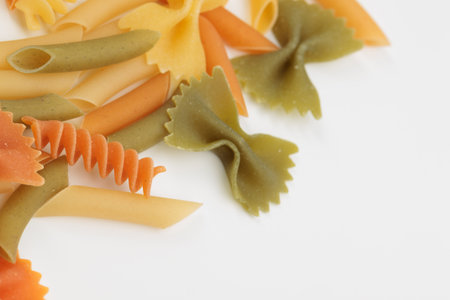 Tricolor macaroni of different types. It is located on a white surface. Close-up.の写真素材