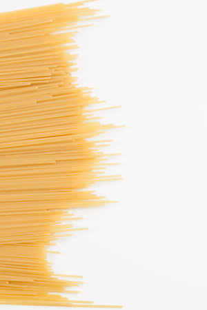 Spaghetti spread out on a white surface. There is a place for the text. Close-up.の写真素材