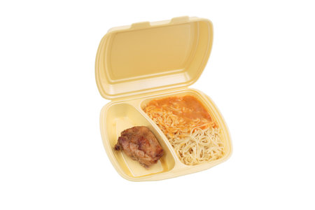 Chicken and pasta in a plastic box. Isolated over white background. Close-up.の写真素材