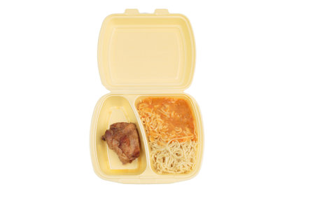 Chicken and pasta in a plastic box for delivery. Isolated over white background. Close-up.の写真素材