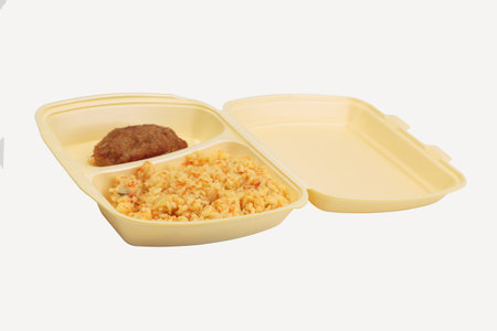 Cutlet and rice in a plastic box for delivery. Isolated over white background. Close-up.の写真素材