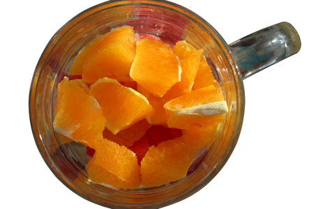 Slices of orange and grapefruit in a glass. Isolated over white background. Close-up.の写真素材