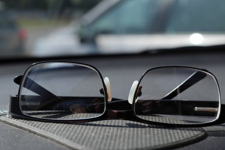 Glasses for vision correction are on the car dashboard. Close-up. The background is blurred.の写真素材