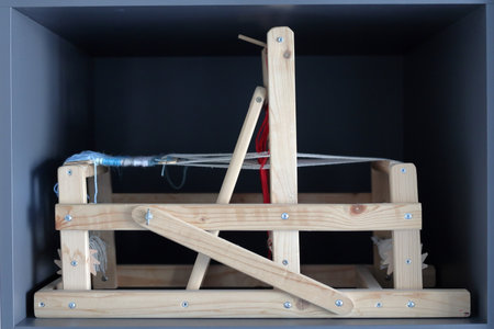 Miniature loom made from wood. Background is dark. Close-up.の写真素材