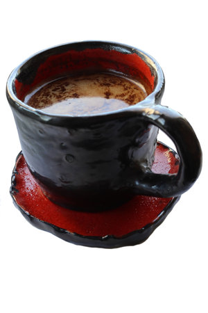 Red and black ceramic coffee cup. Isolated over white background. Close-up.の写真素材