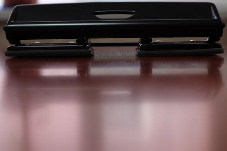 Metal hole punch. For making holes for paper. A hole punch machine. Sprinkle with paper punch. For office stitching. Black. Close-up. Place for text.の写真素材
