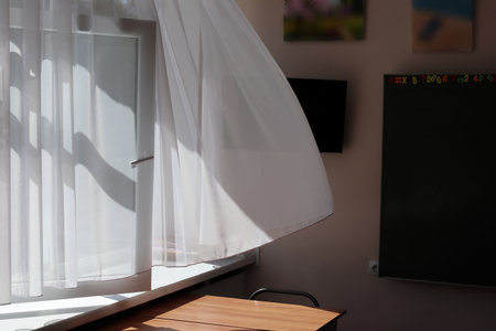 A light white curtain sways in the room. A draft is in the room on a sunny day. Close-up.の写真素材