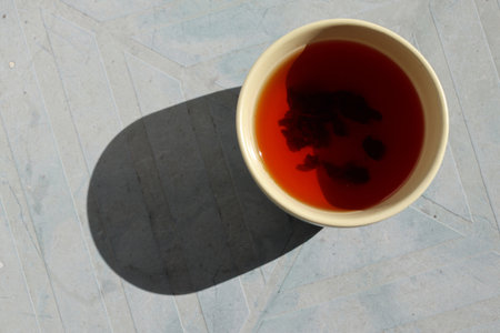 Tea cup with black tea. A beam of light illuminates the cup. Close-up.の写真素材