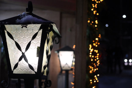 Glowing street lights and festive garlands. Close-up.の写真素材