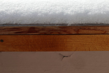 Fluffy snow lies on the wooden windowsill. Close-up.の写真素材