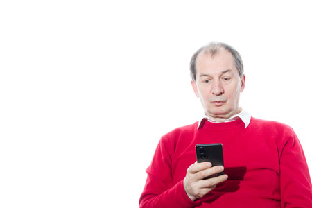 Portrait of a sixty-year-old man in a red pullover. Isolated over white background. Close-up.の写真素材