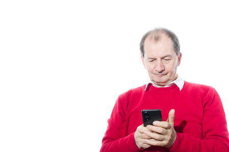 Portrait of a sixty-year-old man in a red pullover. Isolated over white background. Close-up.の写真素材