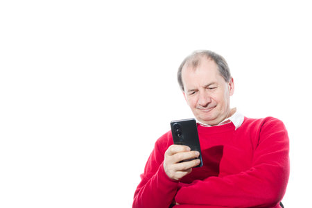 Portrait of a sixty-year-old man in a red pullover. Isolated over white background. Close-up.の写真素材
