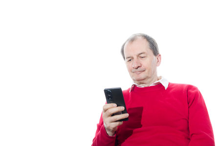 Portrait of a sixty-year-old man in a red pullover. Isolated over white background. Close-up.の写真素材