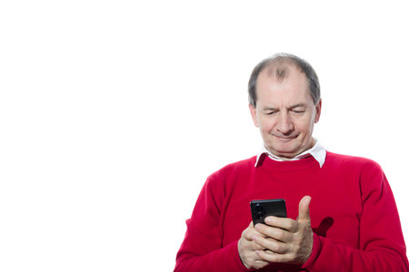 Portrait of a sixty-year-old man in a red pullover. Isolated over white background. Close-up.の写真素材