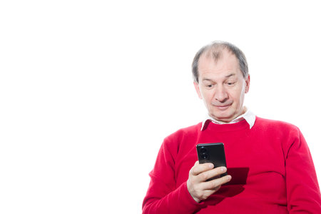 Portrait of a sixty-year-old man in a red pullover. Isolated over white background. Close-up.の写真素材