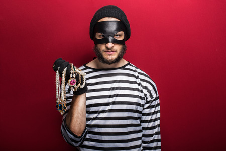 A thief holding stolen necklace  の写真素材