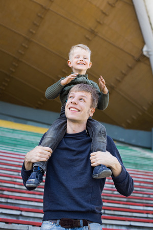The child is sitting on his dad s shoulders and looks happy  の写真素材