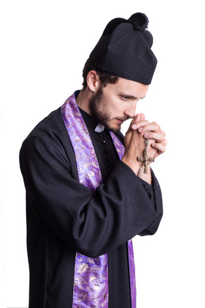 Christian priest praying. Studio portrait isolated on white backgroundの写真素材