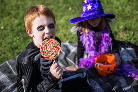 Boy and girl wearing halloween costume with candies. Outdoor portraitの写真素材