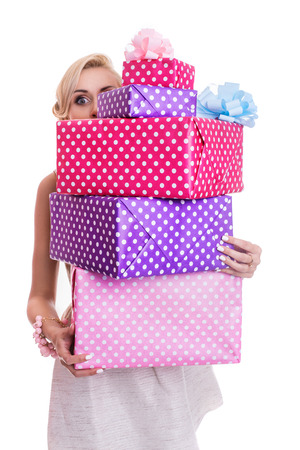 Beautiful blonde woman looking through colorful gift boxes. Studio portrait isolated over white backgroundの写真素材