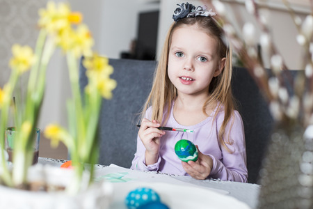A happy little child coloring easter eggs. Cozy home atmosphere. Easterの写真素材