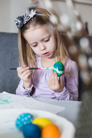 A happy little child coloring easter eggs. Cozy home atmosphere. Easterの写真素材
