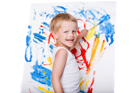 Little boy painting on canvas. Education. Creativity. Studio portrait over white backgroundの写真素材