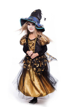 Adorable little blond girl wearing a witch costume smiling at the camera. Halloween. Fairy. Tale. Studio portrait isolated over white backgroundの写真素材