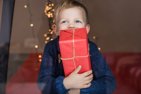 Portrait of a happy little boy holding a new gift. Christmas. Birthdayの写真素材