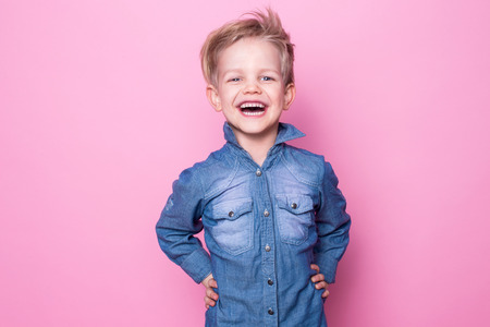 Portrait of happy joyful beautiful little boy. Studio portrait over pink backgroundの写真素材