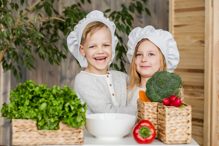 Kids in the kitchen making vegetable salads. Healthy food. Vegetables. Familyの写真素材