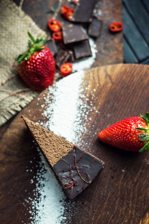 Piece of dark chocolate cake with strawberry. The restaurant or cafe atmosphere. Retro. Vintageの写真素材