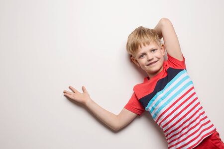Little smiling boy in t-shirt isolated on white background. Studio portraitの写真素材