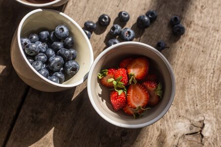 Blackberry and strawberry in bowl over wooden background. Close up, top view, high resolution product. Harvest Conceptの写真素材