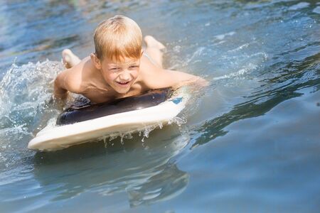 Little boy with surfboard having fun. Vacation, summer and childhood conceptの写真素材