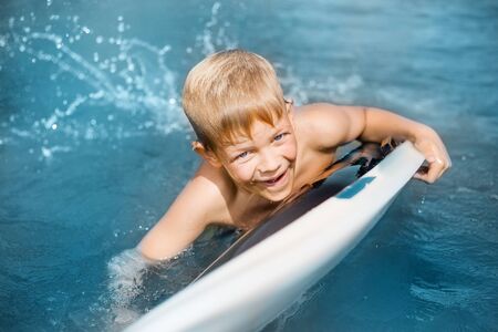 Little boy with surfboard having fun. Vacation, summer and childhood conceptの写真素材