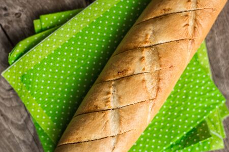 Sliced long french bread over wooden table. Baguette. Restaurantの写真素材