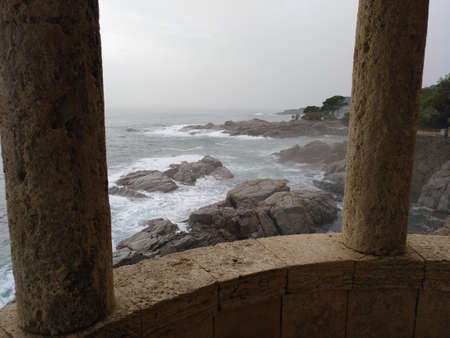 View of the rough sea, on a gray and wet day, from the S'AgarÃ³ viewpoint (Girona)の写真素材