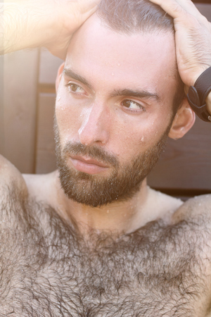 Fashion Portrait of handsome masculine guy with drop of water on Ð° face with Brown dark eyes Beard and mustacheの写真素材