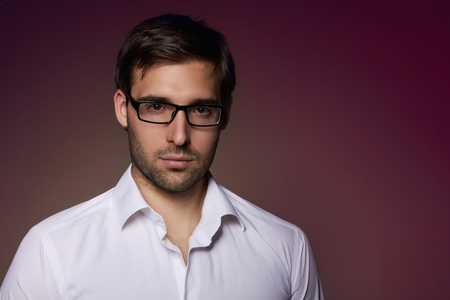 Portrait of handsome smartlooking businesslike Financier or agent or manager in eyeglasses and white shirtの写真素材