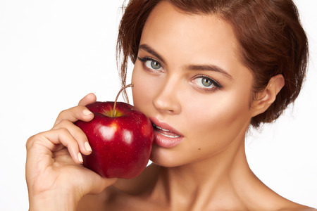 Young beautiful sexy girl with dark curly hair holding appleの写真素材