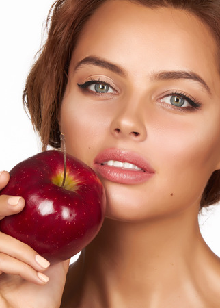 Young beautiful sexy girl with dark curly hair holding appleの写真素材