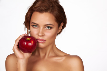 Young beautiful sexy girl with dark curly hair holding appleの写真素材